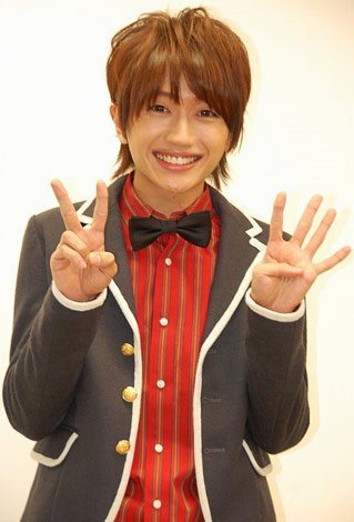 可愛らしいジャケット姿の西島隆弘さん。両手で「2」「4」を作って「にっしー」を表現しています。