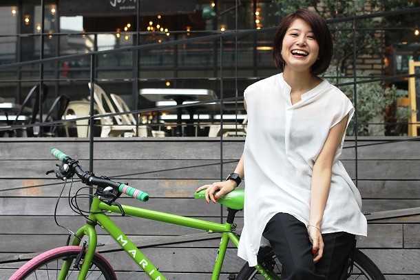 ホワイトのシャツでライムグリーンのシティバイクに乗る佐津川愛美さん。人の目を気にしてしまうタイプらしいです。